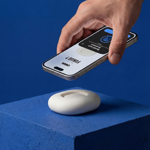 Hand holding a smartphone above a white device on a blue background